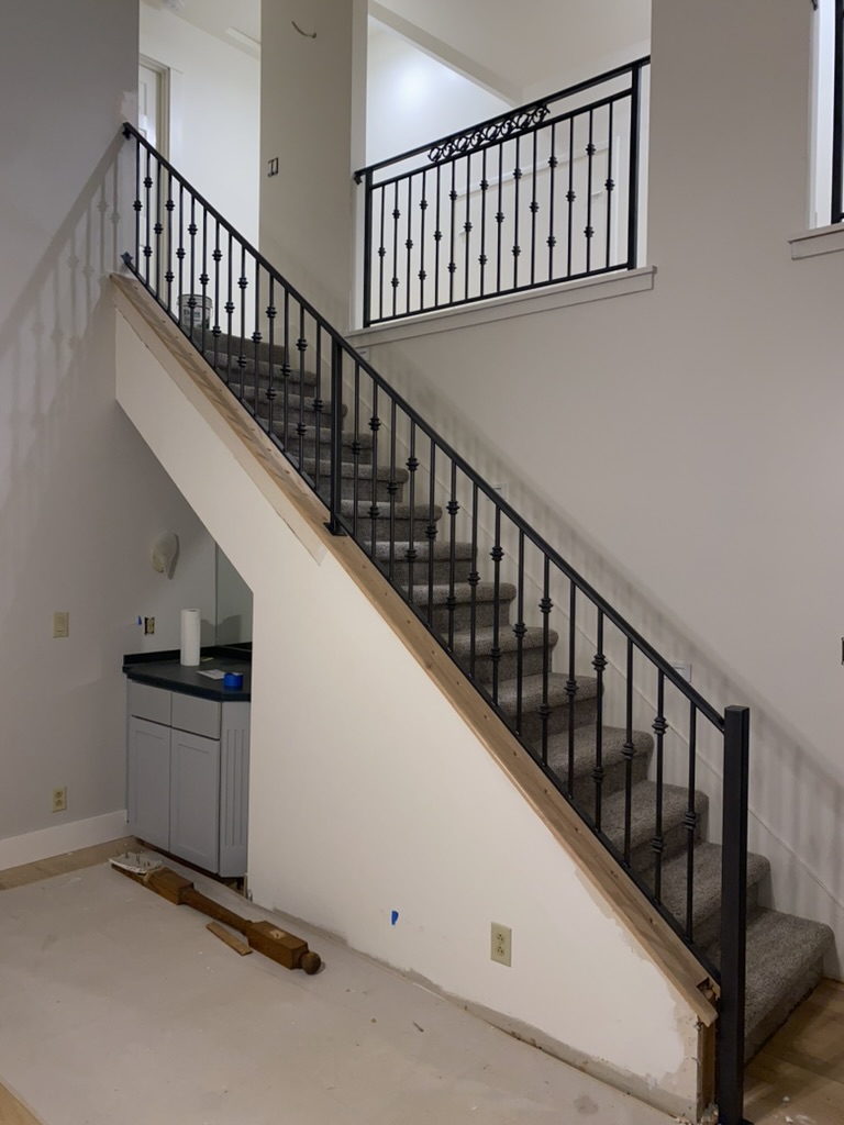custom metal railing around stairs in new house